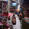 Tourists enjoying themselves in rowing boats at Damnoen Saduak floating market. Visit Damnoen Saduak on our private floating market tour from Bangkok.