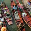 Farmers buying and selling produce at Tha Kha floating market. Visit this authentic market on our private floating market tour from Bangkok.