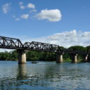 The Bridge over the River Kwai seen from a boat. Visit the famous bridge with us on a private tour from Bangkok.