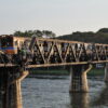 Train crossing the famous Bridge over the River Kwai in Kanchanaburi