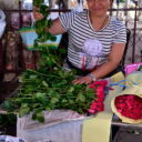 Vendor packing roses in old newspapers at Bangkok's biggest flower market