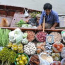 A shopper stops by to chat with the vendor at Tha Kha floating market